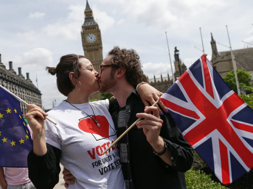 People pose kissing each other in a kiss chain holding EU and Union flags organised by pro-Europe 'remain' campaigners seeking to avoid a Brexit in the EU referendum in Parliament Square in front of the Houses of Parliament in central London on June 19, 2016. Photo: AFP