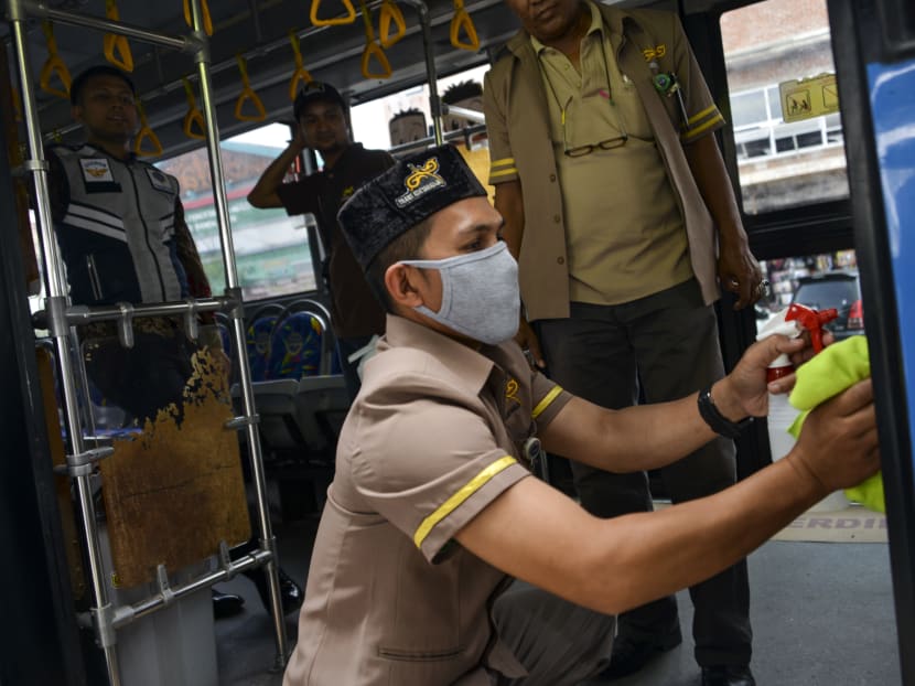 A worker sprays disinfectant on a bus as part of preventive measures against the spread of the Covid-19 coronavirus, in Banda Aceh on March 5, 2020.