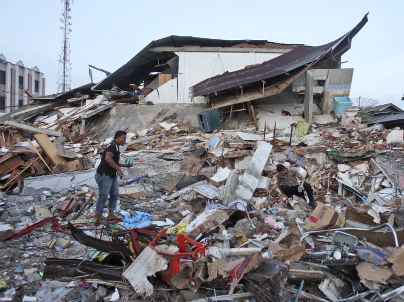 This file photo shows a man searching through rubble in after a quake hit the Aceh province in December 2016. On Feb 16, the area was hit by two earthquakes in the early morning. AP file photo