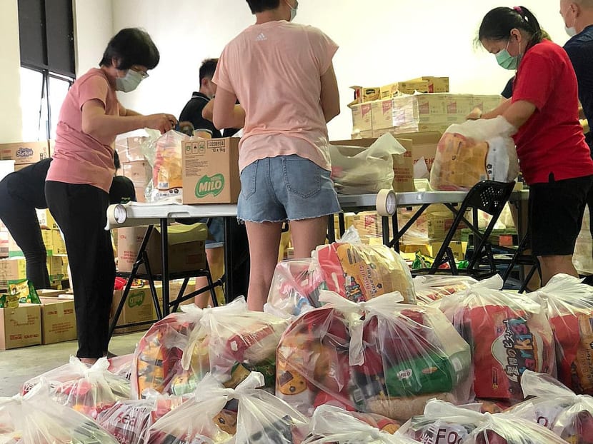 Volunteers with Food from the Heart sorting and packing food items for needy households at a warehouse.