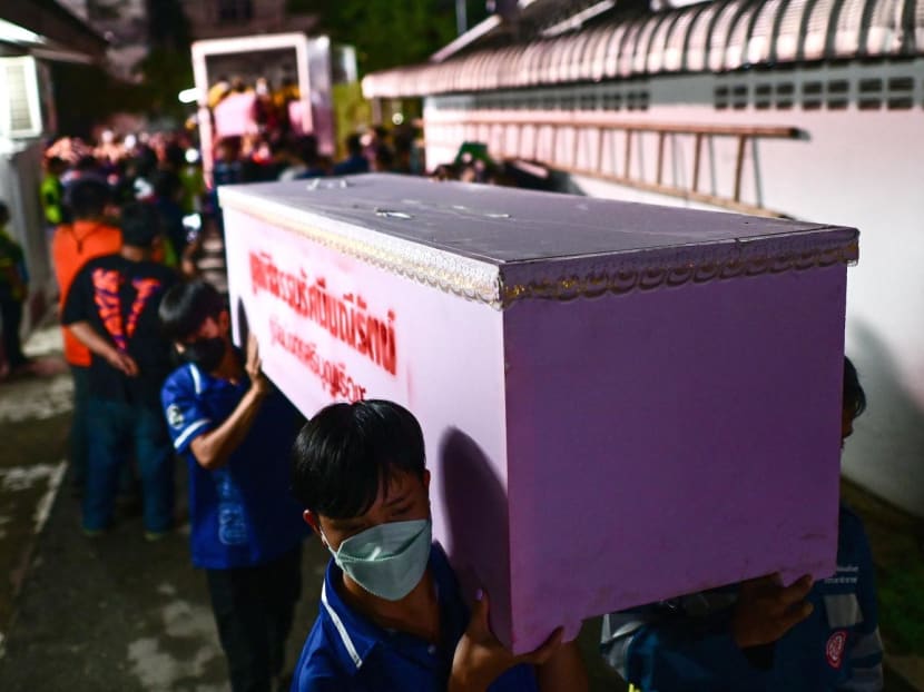 Rescue personnel carry a victim’s coffin at the hospital morgue in Udon Thani on Oct 6, 2022 following a mass shooting at a nursery by a former policemen.