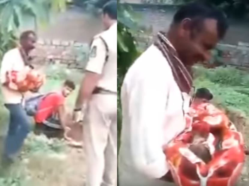 Mobile phone footage of the incident, which has since gone viral on social media, shows police officers approaching and confronting a man holding a bundle of blankets, as another man nearby digs a hole in the ground with his hands.