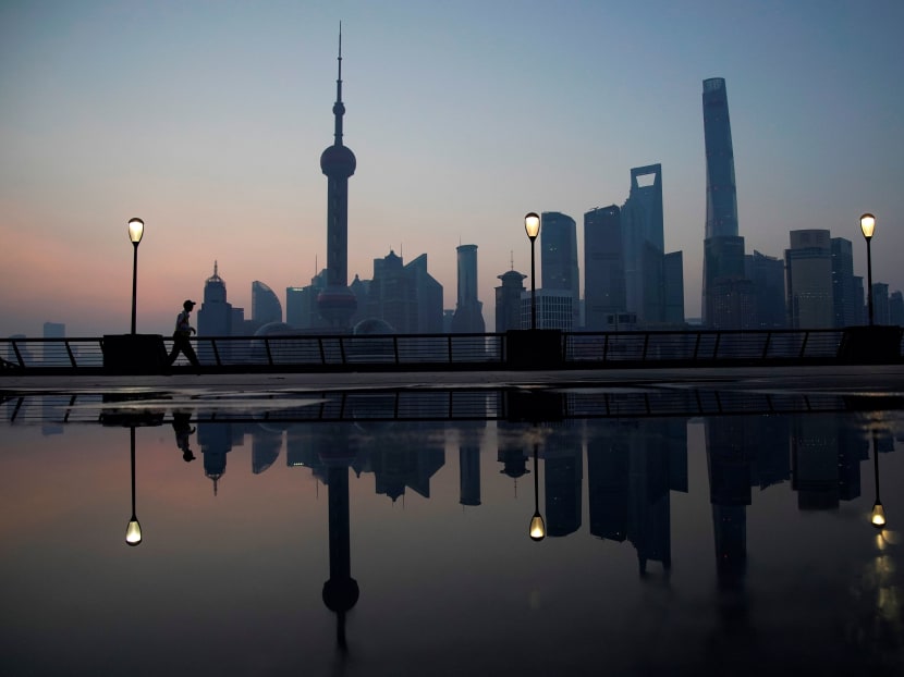 A security guard walks on the bund in front of the financial district of Pudong in Shanghai, China.  Photo: Reuters