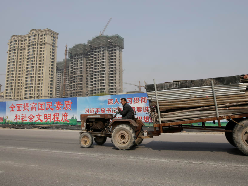 A man drives a tractor carrying building materials past a property under construction, which has been closed to sale, as the government banned new property sales in counties earmarked as part of a new special economic zone in Xiongxian county, Hebei province, China, April 3, 2017. Photo: Reuters