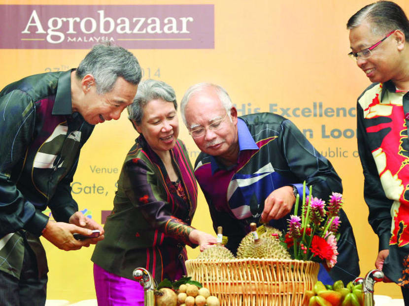 PM Lee Hsien Loong and Mdm Ho Ching accepting a gift of tropical fruits from Malaysia's PM Najib Razak and Malaysia's Minister of Agriculture and Agro-Based Industry Ismail Sabri bin Yaakob during the opening ceremony of Agrobazar, on August 28, 2014. Photo: Don Wong