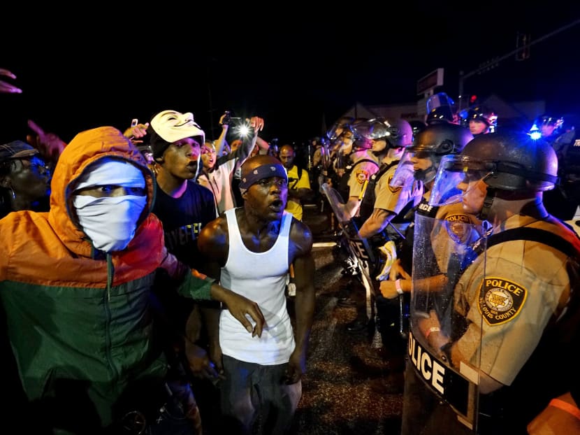 Protesters yell at a police line shortly before shots were fired in a police-officer involved shooting in Ferguson, Missouri August 9, 2015.  Photo: Reuters
