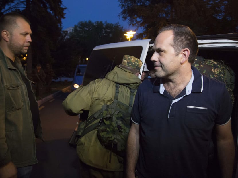 An unidentified member of the OSCE Special Monitoring Mission in Ukraine gets out of a vehicle next to Alexander Borodai, Prime Minister of the self proclaimed 'Donetsk People's Republic', left, on arrival in the city of Donetsk, eastern Ukraine Saturday, June 28, 2014. Photo: AP
