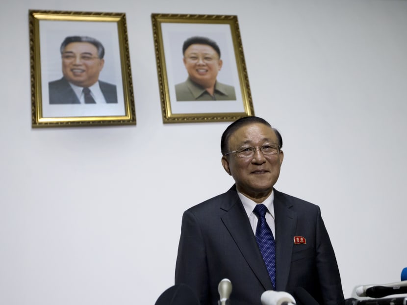 Under the portraits of the late North Korean leaders, Kim Il Sung, left, and Kim Jong Il, North Korean Ambassador to China Ji Jae Ryong stands up to leave after a press conference at the North Korean Embassy in Beijing, on July 28, 2015. Photo: AP