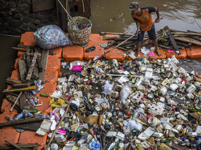 Workers collect and separate trash at a floodgate in the Manggarai neighborhood of Jakarta. Photo: New York Times