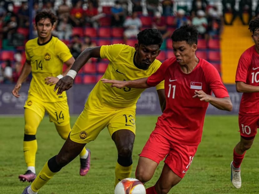 Singapore and Malaysia players vie for the ball in their SEA Games football match on May 11, 2023.