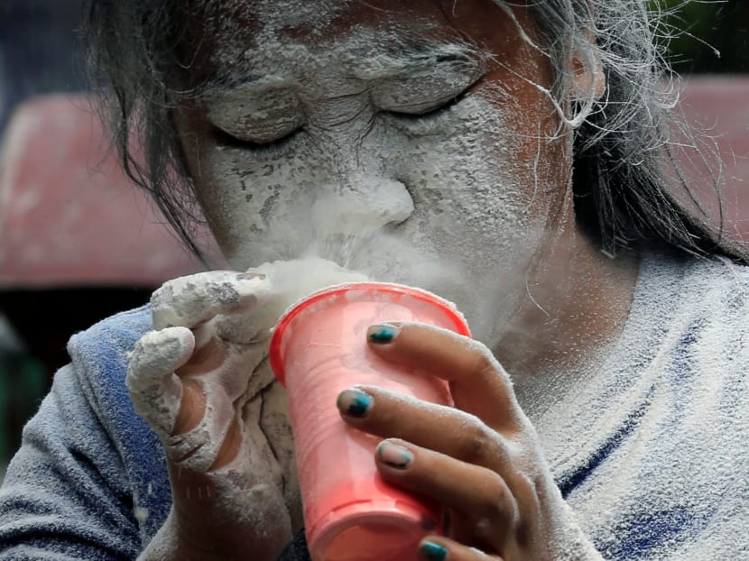 A girl's face is covered by white powder after blowing on it, while participating in a game during a religious festival honouring patron saint Santa Rita de Cascia in Paranaque city, metro Manila, Philippines on May 21, 2017. Photo: Reuters