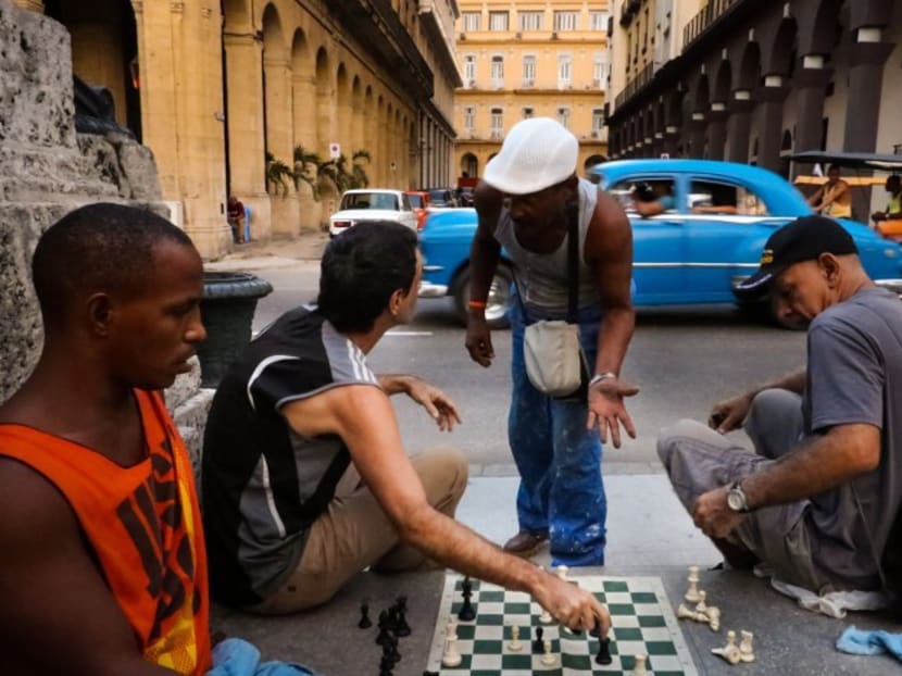 Cubans play chess by the streets. Photo: AFP