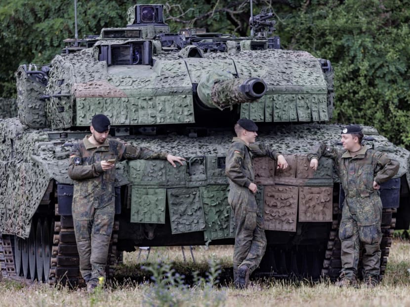 Soldiers of the German Armed Forces (Bundeswehr) standing in front of a battle tank "Leopard" at the Digitalisation Unit of Land-Based Operations of the German Armed Forces (Bundeswehr) in Munster, northwestern Germany.