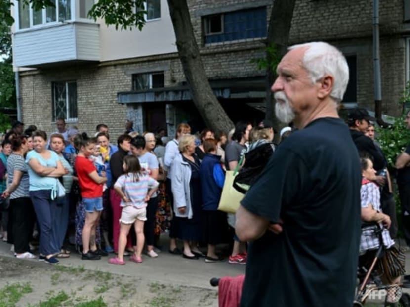 People queue as they wait for humanitarian aid in the town of Bucha, north-west from Ukrainian capital of Kyiv on June 3, 2022 on the 100th day of the Russian invasion of Ukraine.