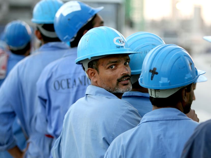 Indian workers line up to board a bus after a day's work in Dubai, November 18, 2005. Photo: Reuters