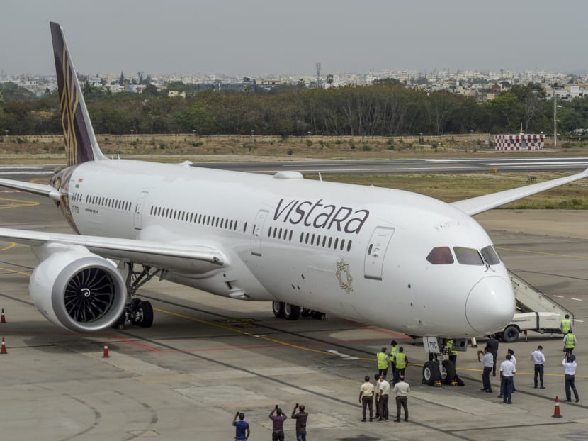 Groundsmen and crew stand near the Vistara Boeing 787-9 displayed at the Wings India 2020 international exhibition at Begumpet Airport in Hyderabad, India on March 14, 2020.