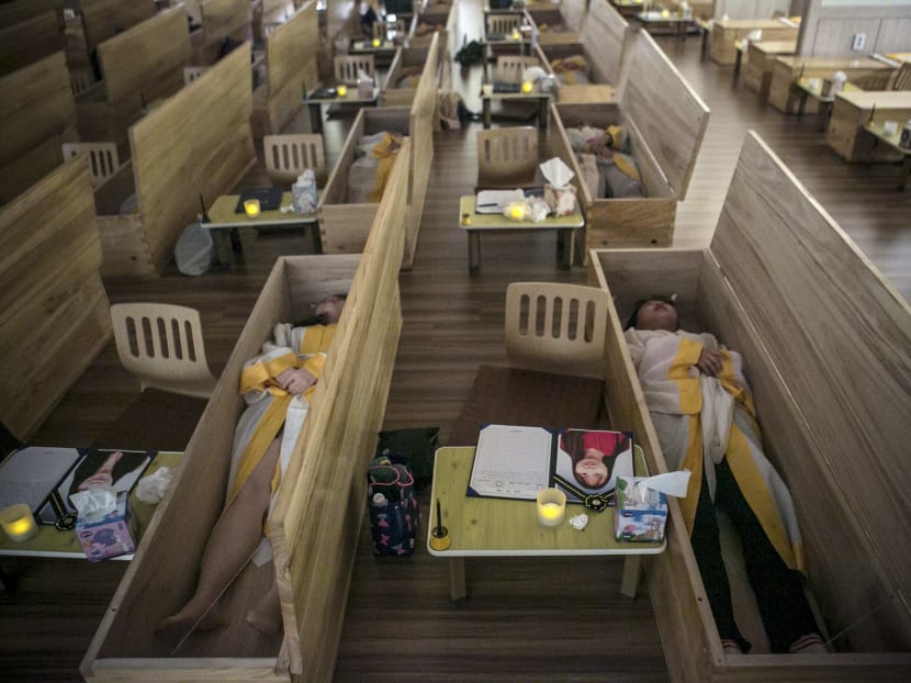 Participants in a special course lie down in coffins after writing their wills at the Hyowon Healing Center in Seoul. Photo: The New York Times