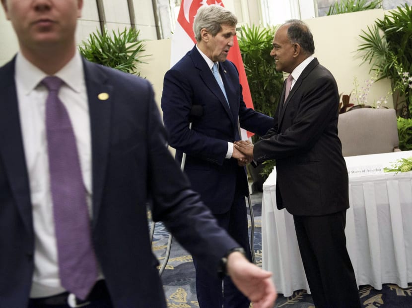 US Secretary of State John Kerry (C) and Singapore's Foreign Minister Kasiviswanathan Shanmugam (R) shake hands while talking after a signing of a memo of understanding at the Shangri-La Hotel in Singapore August 4, 2015. Photo: Reuters