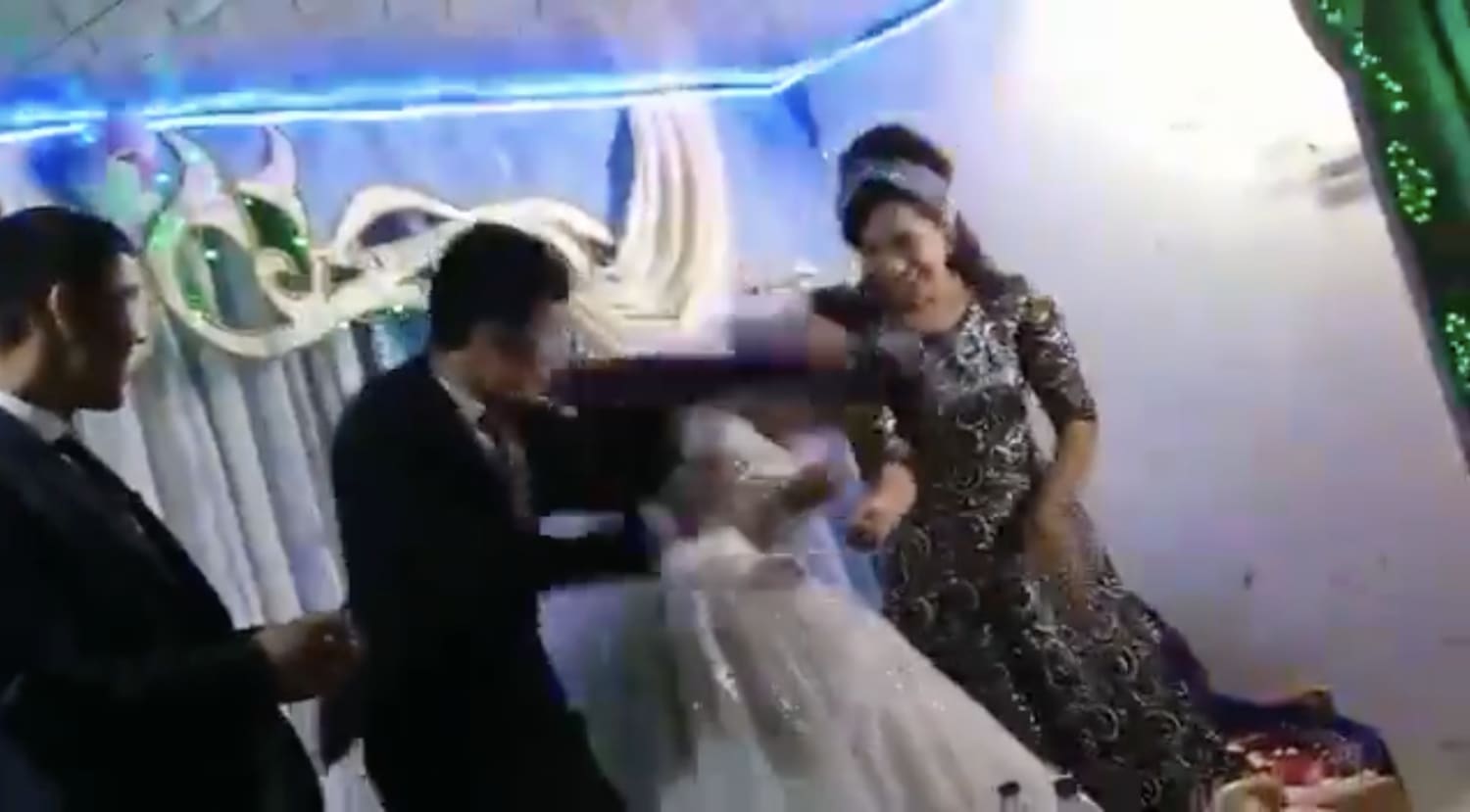 In a video posted on Twitter, a groom hits his new bride after losing to her in a game at their wedding. In a video posted on Twitter, a groom hits his new bride after losing to her in a game at their wedding.