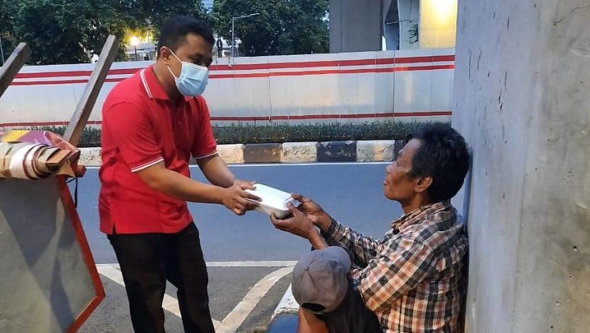 Dengan upah minimum, office boy bagi-bagi makanan gratis kepada tunawisma di Jakarta