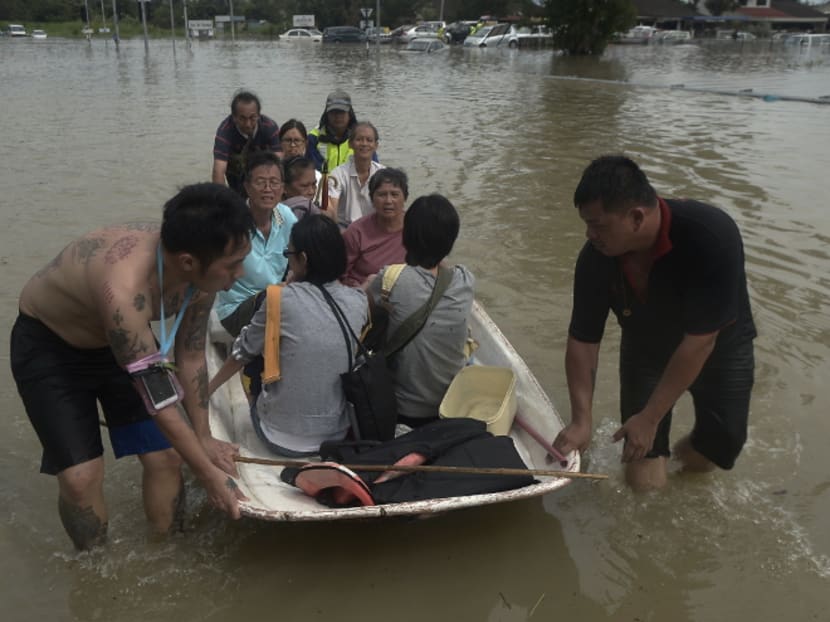 Volunteers brave the flood waters to guide boats ferrying flood victims in Penang. Abnormal downpour caused by climate change has rendered Penang’s current flood mitigation system obsolete and in need of a major revamp, a Malaysian minister said on Monday (Nov 6) Photo: Malay Mail Online