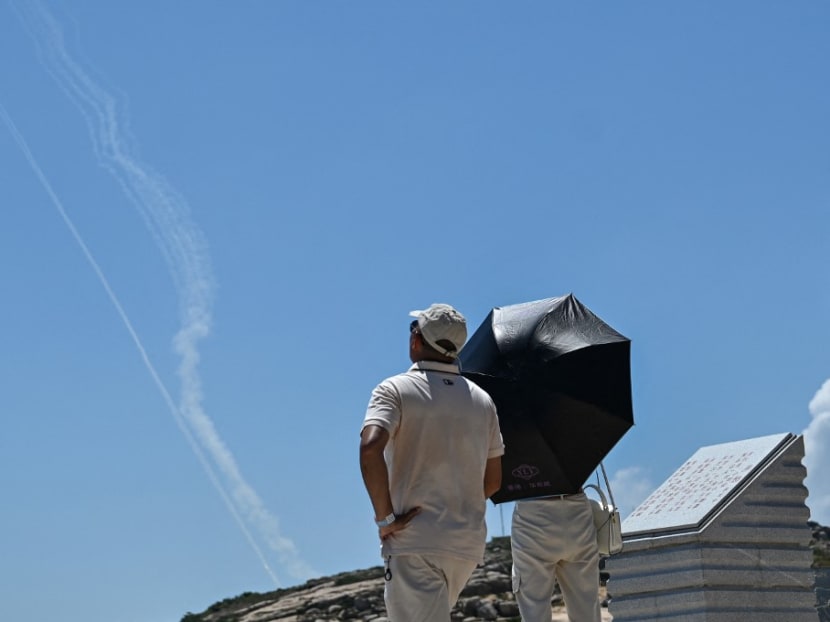 Smoke trails from projectiles launched by the Chinese military are seen in the sky as tourists look on from Pingtan Island, one of mainland China's closest point from Taiwan, in Fujian province on Aug 4, 2022. Smoke trails from projectiles launched by the Chinese military are seen in the sky as tourists look on from Pingtan Island, one of mainland China's closest point from Taiwan, in Fujian province on Aug 4, 2022.