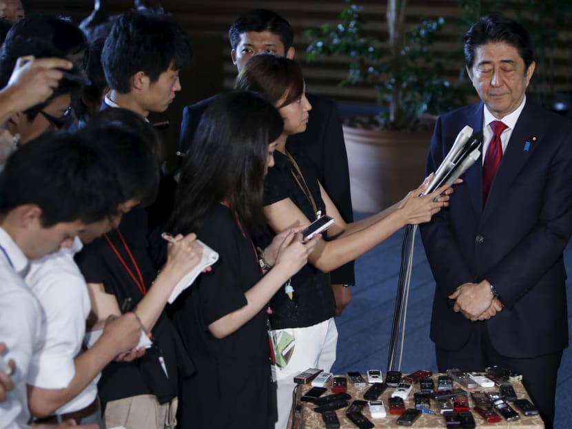 Japan's Prime Minister Shinzo Abe (R) speaks to reporters after meeting with Yoshiro Mori (not in picture),  the president of the Tokyo 2020 Organizing Committee of Olympic and Paralympic games, at Abe's official residence in Tokyo July 17, 2015. Photo: Reuters