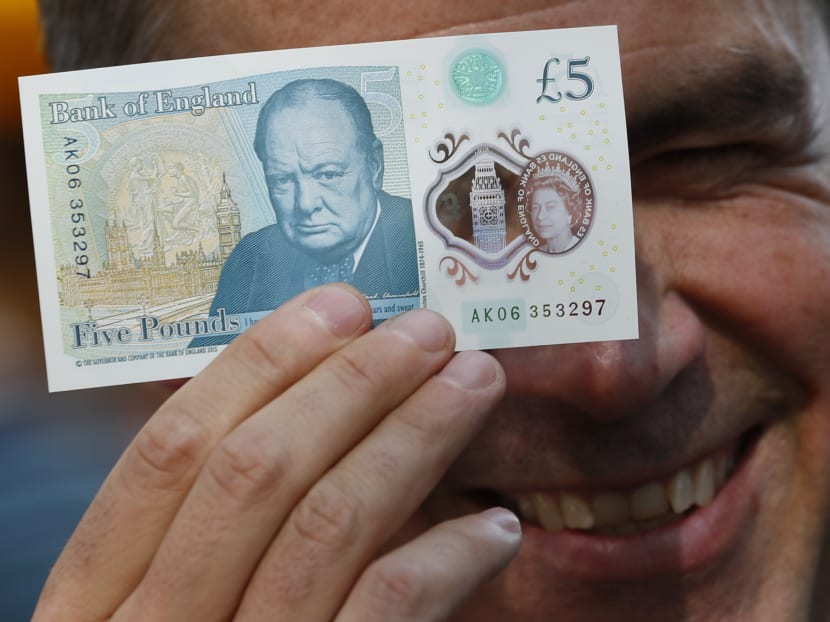Bank of England governor Mark Carney poses with a new polymer £5 note at Whitecross Street Market in London, Britain Sept 13, 2016. Photo: Reuters