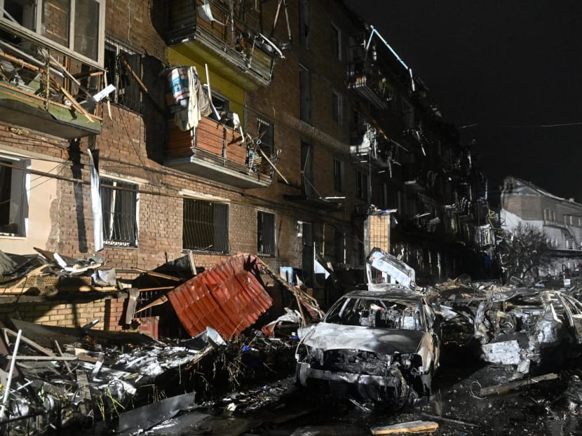 Burnt cars are seen in front of a damaged residential building, following a Russian strike in the town of Vyshgorod on the outskirts of Kyiv on Nov 23, 2022.