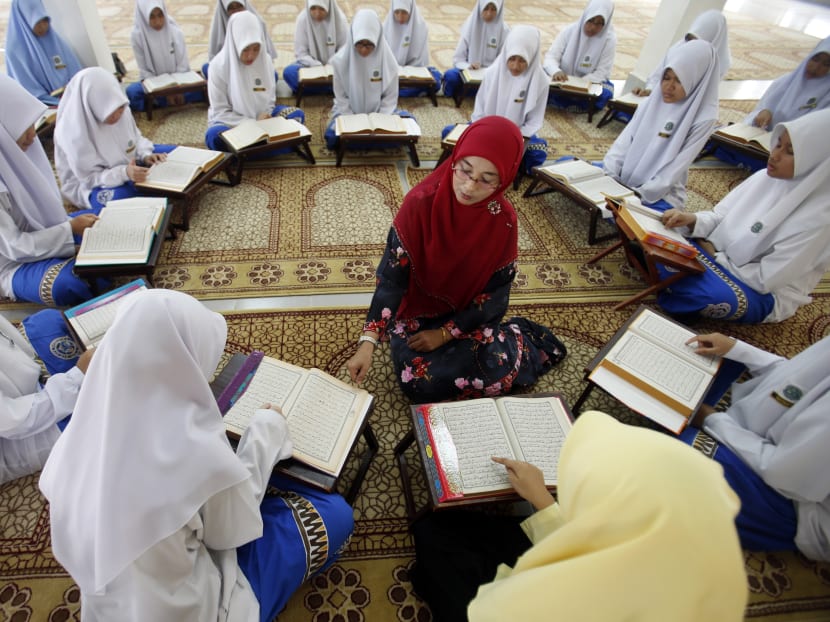 Muslim schoolgirls sit in a circle around their teacher in Putrajaya. Malaysian Education Minister Mahdzir Khalid warns teachers and officers with the Education Ministry not to support the Opposition. Photo: Reuters