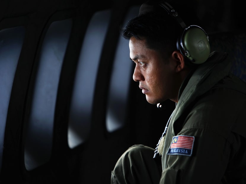 A crew member from the Royal Malaysian Air Force looks through the window of a Malaysian Air Force CN235 aircraft during a Search and Rescue (SAR) operation to find the missing Malaysia Airlines flight MH370, in the Straits of Malacca in this March 13, 2014 file photo. Photo: Reuters