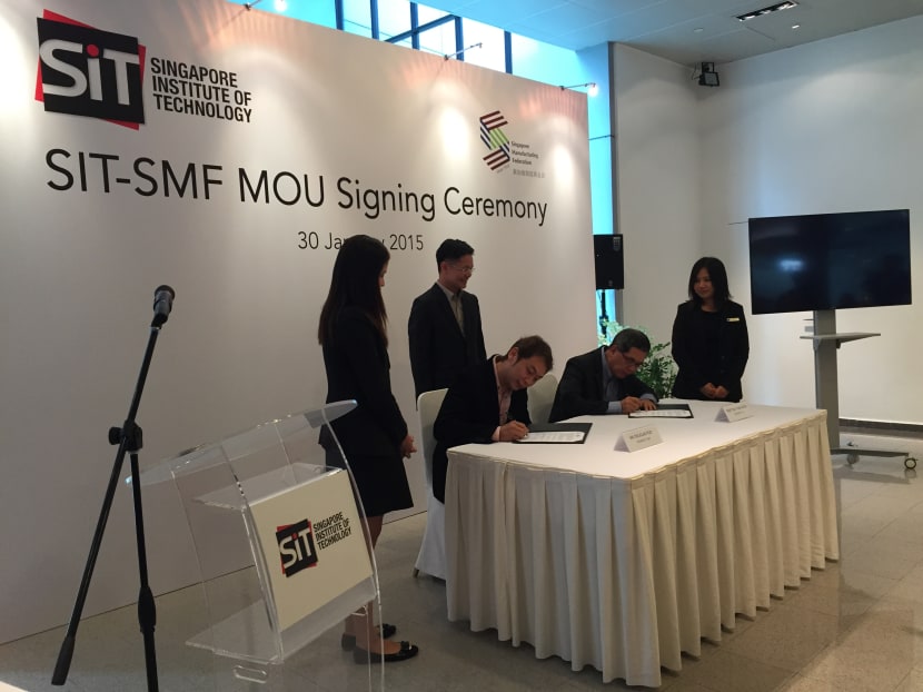 SMF President Douglas Foo (left) and SIT President Tan Thiam Soon signs the MOU, which aims to address the manpower crunch in the manufacturing industry by identifying skills gaps to produce skilled workers. Photo: Elgin Chong/TODAY
