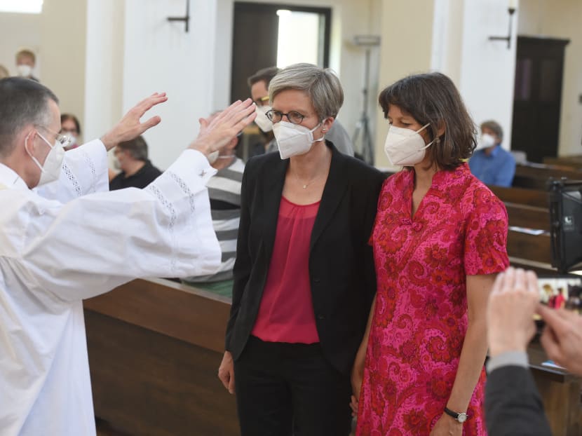 Parish vicar Wolfgang Rothe (centre) blesses a lesbian couple Christine Walter (left) and Almut Muenster during a church service at Saint Benedikt church in Munich, Germany on May 9, 2021.