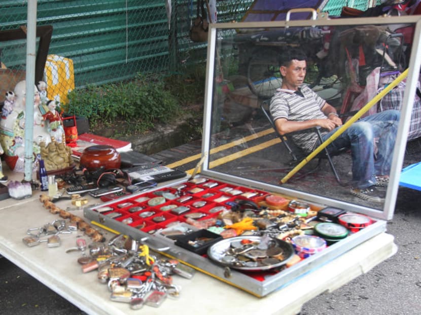 A vendor sits around on a slow weekday afternoon when foot traffic at the Thieves' Market is low. Photo: Ooi Boon Keong/TODAY