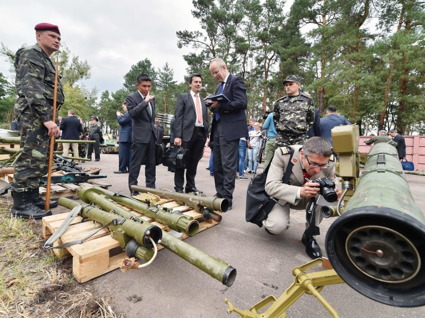 Military attaches examining a Russian weapons cache in Kiev yesterday. Russian weapons and artillery, seized by Ukrainian forces from pro-Russian separatists following clashes in the east of the country, were displayed for inspection by foreign military attaches accredited in Ukraine. PHOTO: AFP
