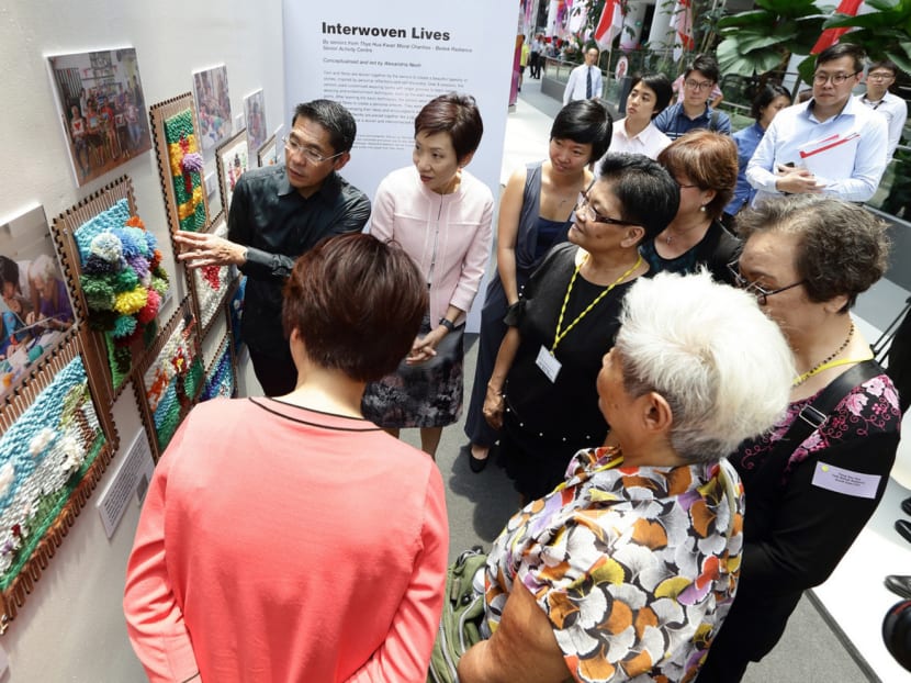 Seniors from the Thye Hua Kwan Moral Charities Bedok Radiance Senior Activity Centre looking at woven designs made with hand-looms which they were taught to use as part of a programme subsidised by the WeCare Arts Fund. Photo: National Arts Council