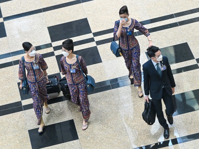 Singapore Airlines crew walk through the transit hall of Changi International Airport in Singapore on Jan 12, 2022.