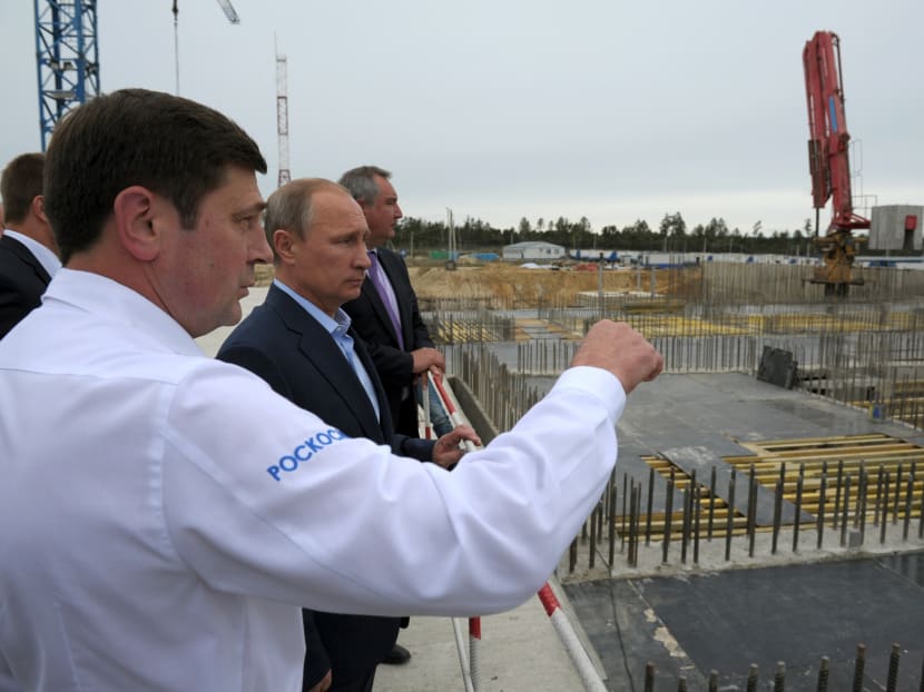In this Sept 2, 2014 file photo, Russian President Vladimir Putin, second left, and Vice Premier Dmitry Rogozin, third left, listen to then Russian Space Agency chief Oleg Ostapenko, left, while visiting a construction site of the Vostochny Cosmodrome near Uglegorsk, eastern Siberia, in the Amur region, Russia. Photo: AP