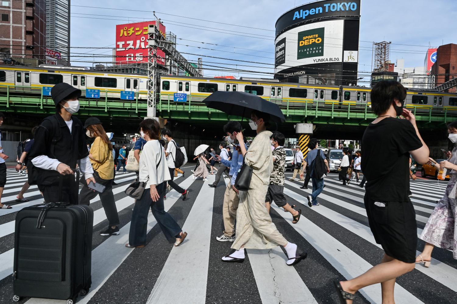 People cross the street in the Shinjuku district of Tokyo on Aug 16, 2022. People cross the street in the Shinjuku district of Tokyo on Aug 16, 2022.