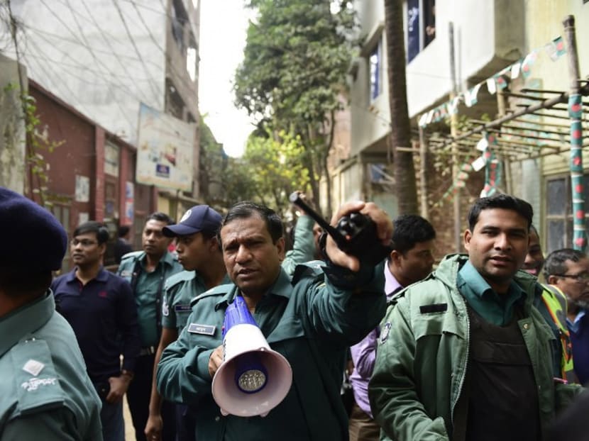 Bangladeshi police officials secure the area following a raid on a building housing militant suspects in Dhaka on Dec 24, 2015. AFP file photo