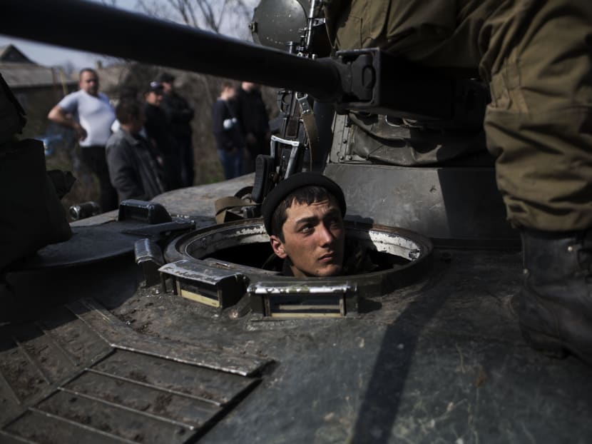 A Ukrainian soldier is seen in a tank of the Ukrainian Army, as they are blocked by people on their way to the town of Kramatorsk, on April 16, 2014. Photo: AP