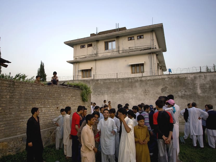 In this May 3, 2011 file photo, local residents gather outside a house, where al-Qaida leader Osama bin Laden was caught and killed in Abbottabad, Pakistan. Photo: AP