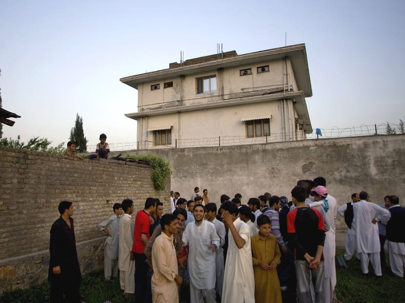 In this May 3, 2011 file photo, local residents gather outside a house, where al-Qaida leader Osama bin Laden was caught and killed in Abbottabad, Pakistan. Photo: AP In this May 3, 2011 file photo, local residents gather outside a house, where al-Qaida leader Osama bin Laden was caught and killed in Abbottabad, Pakistan. Photo: AP