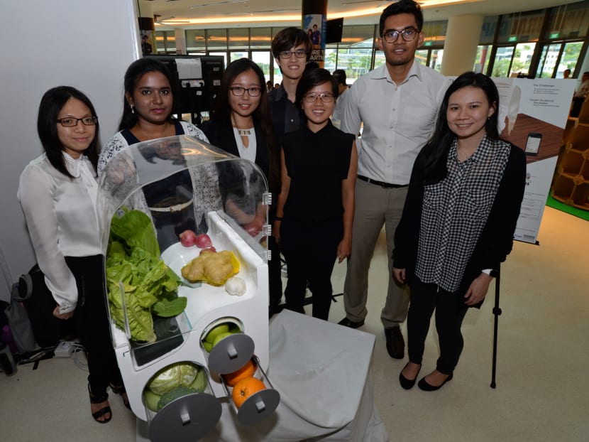 (L-R) SUTD final year students Cynthia Tong, Nivedethaa Palaniappan, Fu Lin, Clarence Teo, Melissa Lim, Adnan Ahmed Salman and their industrial partner from Samsung Ms Jane Tang with their capstone project The Fresh Box, a smart and energy-efficent table top storage device to store fruits and vegetables. Photo: Robin Choo