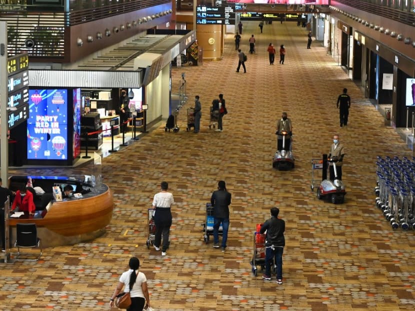 People walking along the transit hall at Changi International Airport in Singapore in January 2021. People walking along the transit hall at Changi International Airport in Singapore in January 2021.