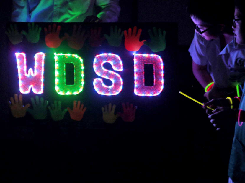 Students of MINDS Fernvale Gardens School and Fernvale Primary school wear glow-in-the-dark wristbands during a special celebration to commemorate Word Down Syndrome Day, between MINDS Fernvale Gardens School and its next-door-neighbour, Fernvale Primary school, on March 21, 2017. Photo: Jason Quah/TODAY