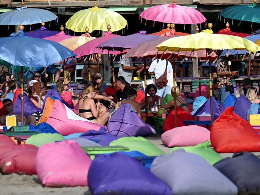 Foreign tourists enjoy their holiday on a beach in Seminyak, Badung regency on Indonesia resort island of Bali on Dec 7, 2022.
