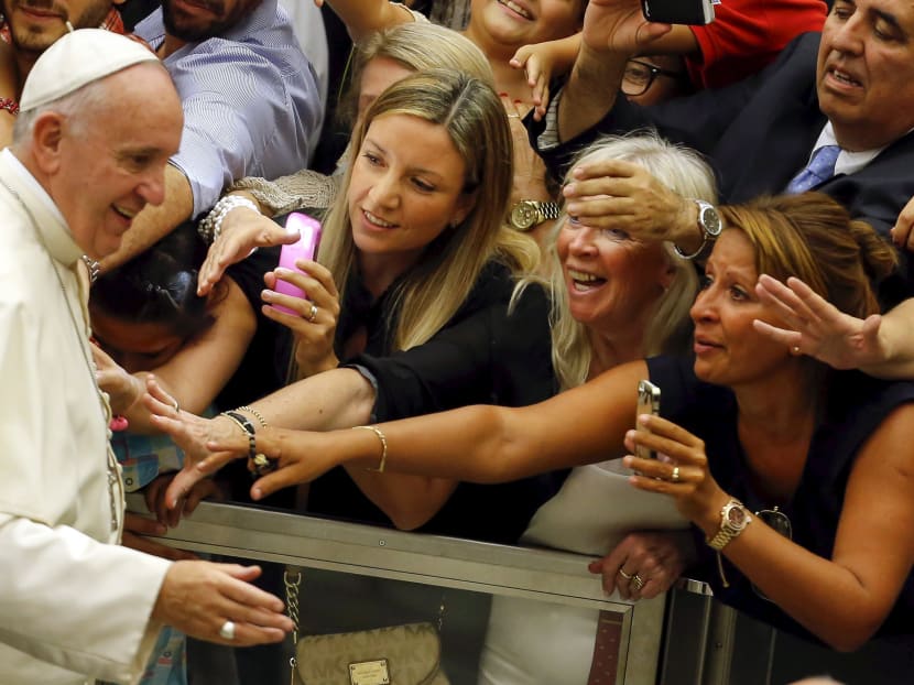 Faithful react as Pope Francis arrives to lead his weekly audience in Paul VI hall at the Vatican City, August 5, 2015. Photo: Reuters
