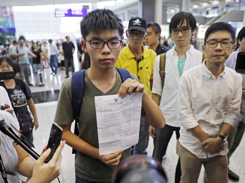 Pro-democracy activist Joshua Wong showing a notice from the Thai immigration office, after arriving at Hong Kong airport from Bangkok, yesterday. PHOTO: AP