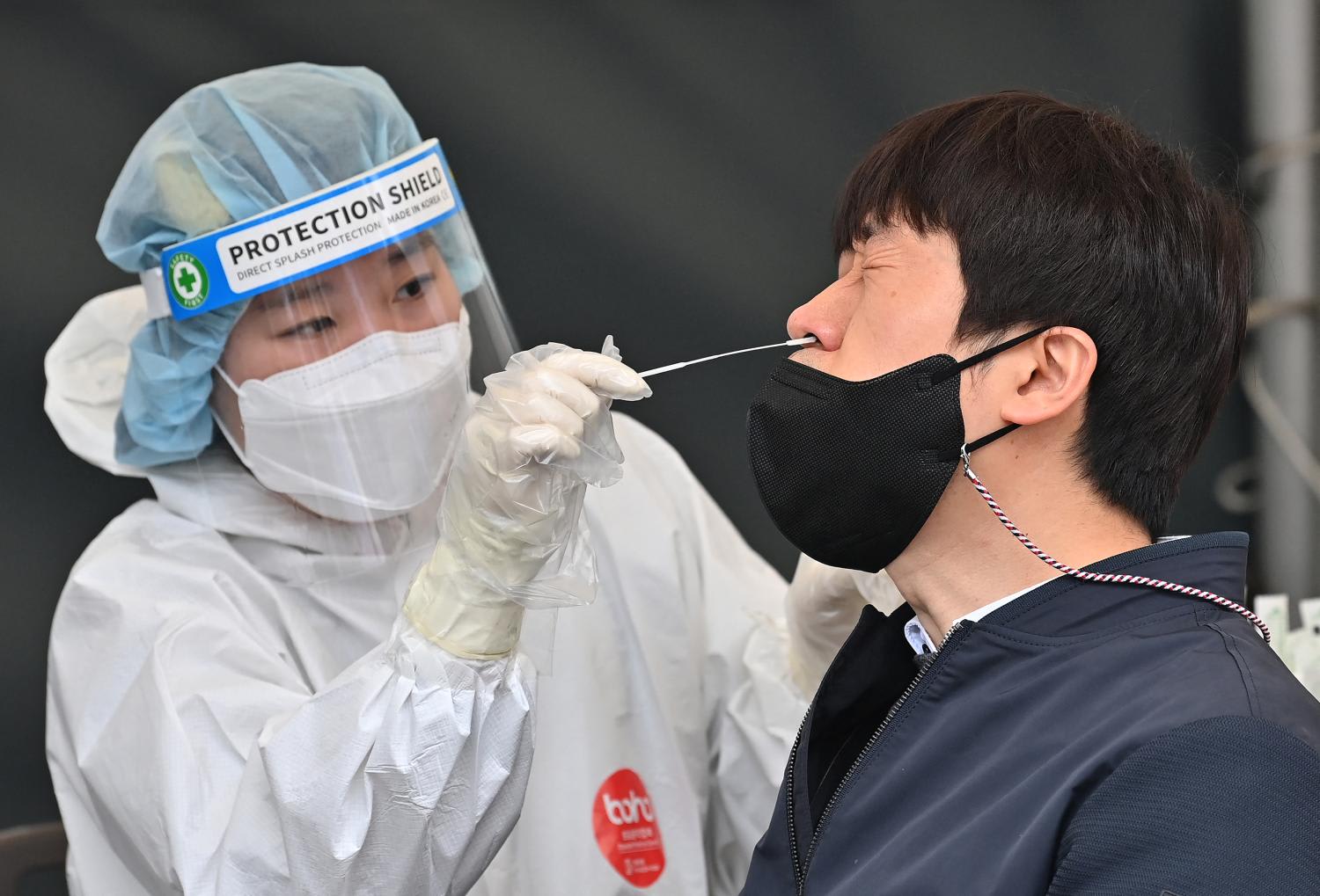 A medical worker takes a nasal swab sample from a man at a Covid-19 coronavirus testing centre in Seoul on March 17, 2022. A medical worker takes a nasal swab sample from a man at a Covid-19 coronavirus testing centre in Seoul on March 17, 2022.